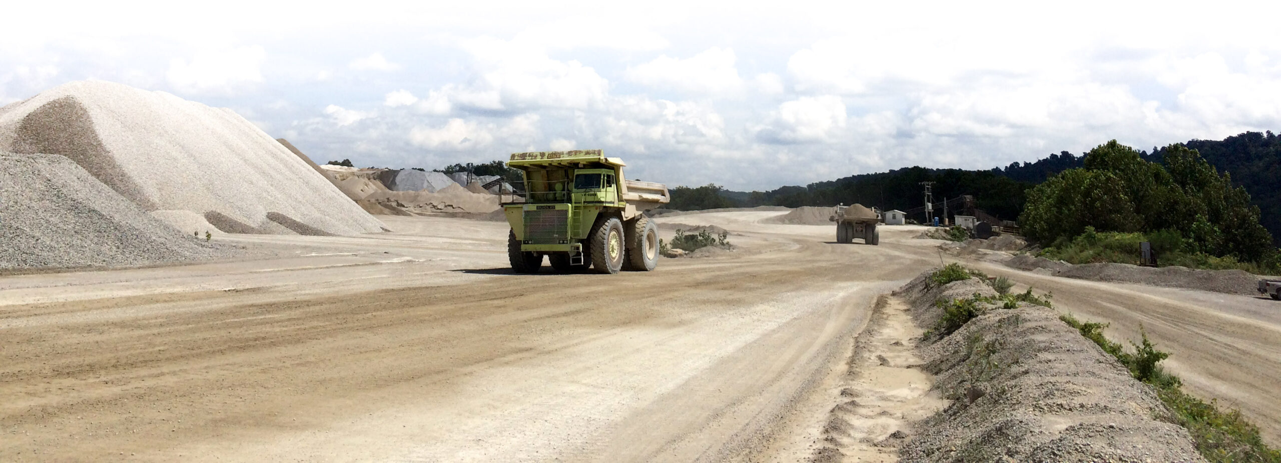 truck surrounded by gravel piles