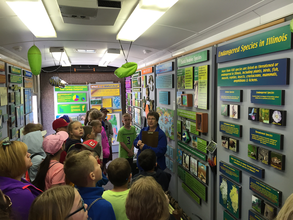 Patty tells a group of students about the Traveling Science Center displays.